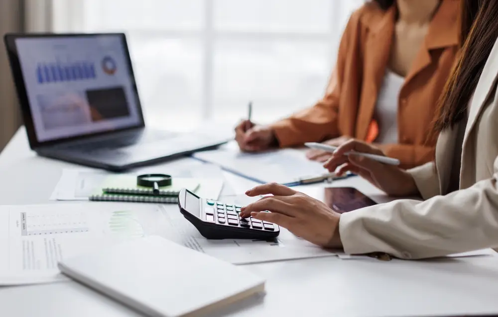 business,team,using,calculator,and,laptop,for,do,math,finance